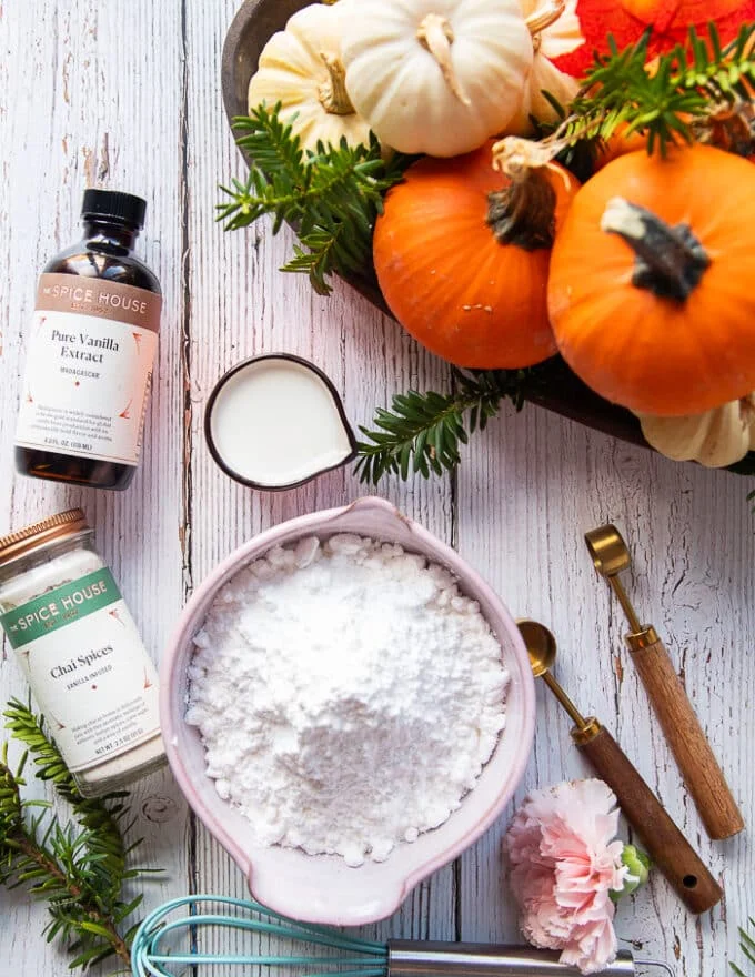 Ingredients for glazing the pumpkin bread including milk, confectioners sugar. vanilla and some chai spice