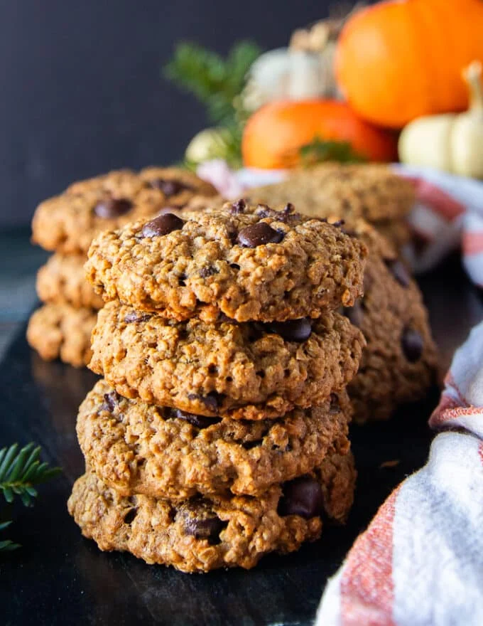 Stack of 5 pumpkin oatmeal cookies on top of each other showing the thickness, texture and chewy cookies studded with chocolate chips