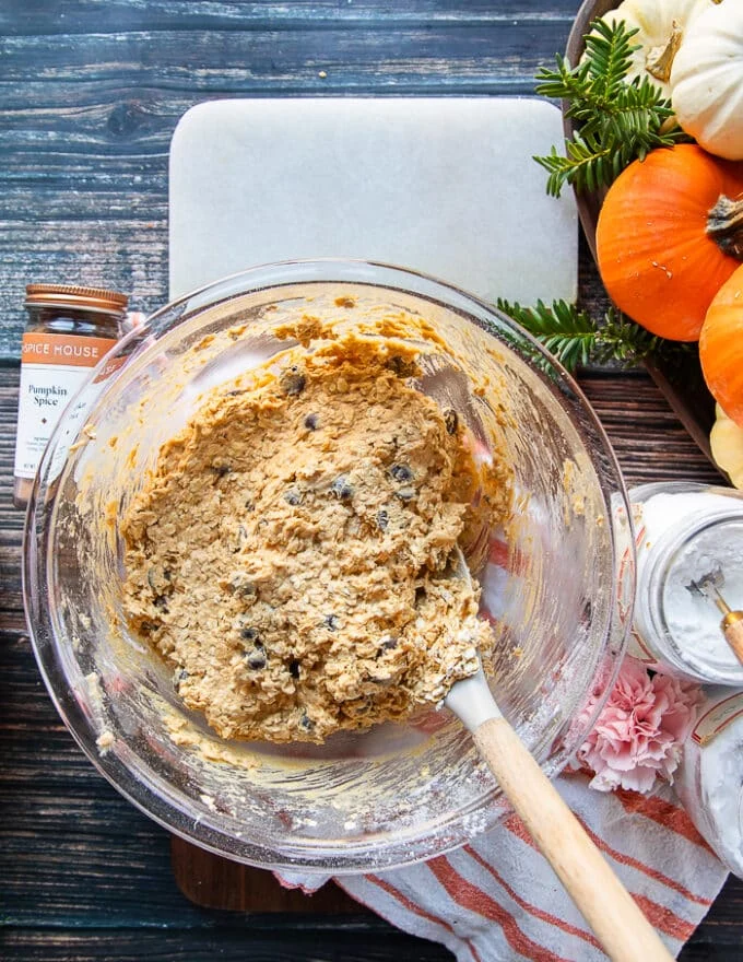 A spatula folding on the chocolate chips and oats for the pumpkin oatmeal cookies