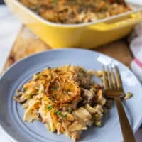 A plate with a serving of tuna casserole and a fork next to it