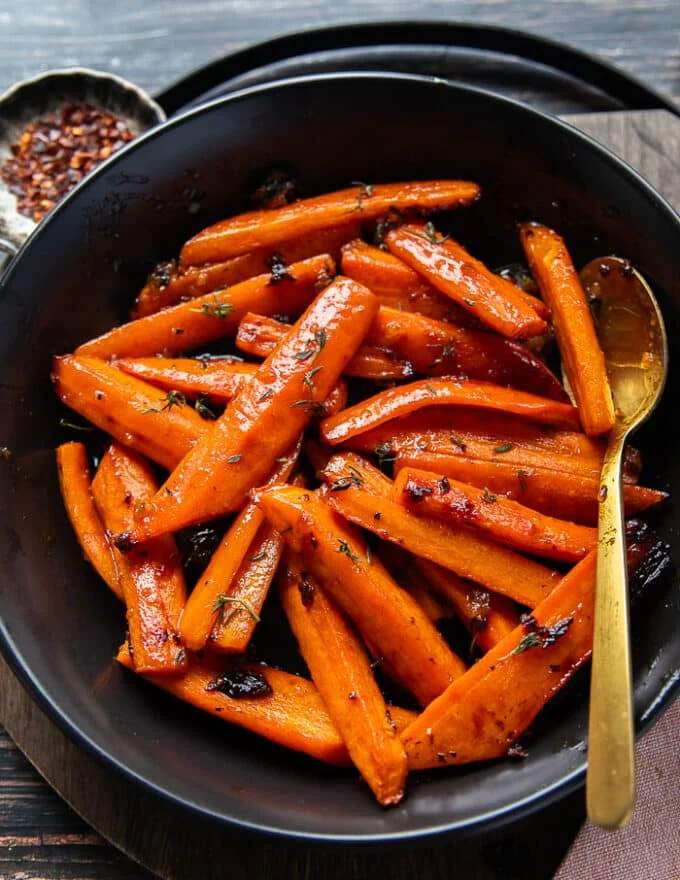 close up of a plate with honey roasted carrots showing the soft sweet and tender carrots laced in honey glaze