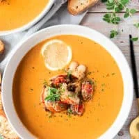 close up of a lobster bisque bowl finished with chunks of succulent lobster
