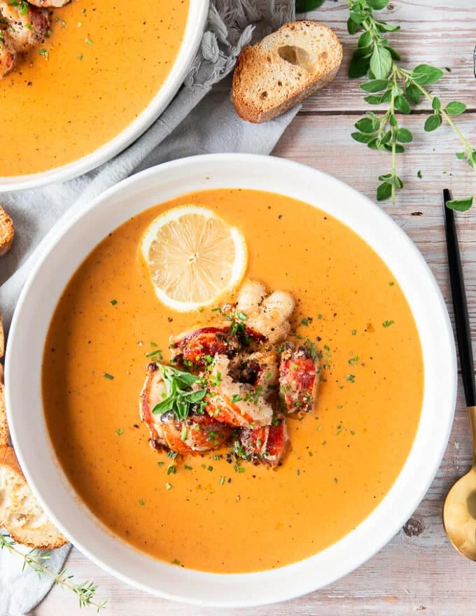 close up of a lobster bisque bowl finished with chunks of succulent lobster