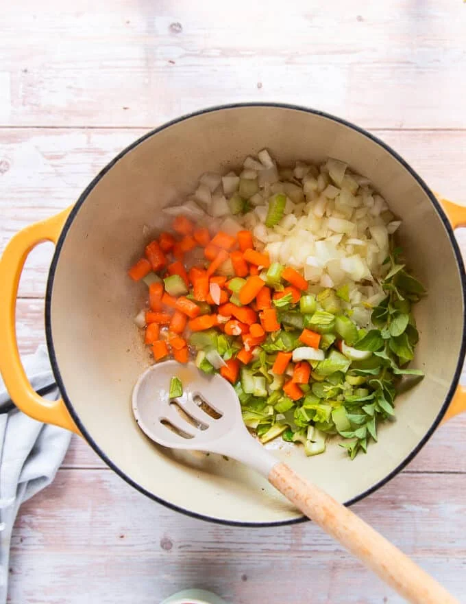 the mirepoix ingredients all added in a pot along with the flavored butter