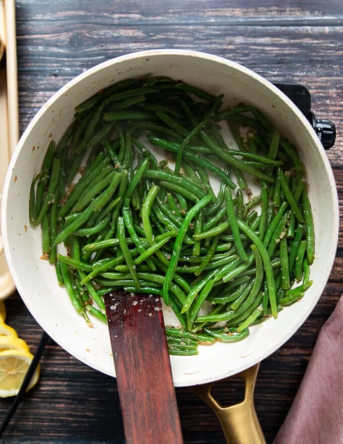 Uncovered skillet with the green beans cooked perfectly over medium low heat for a few minutes until tender