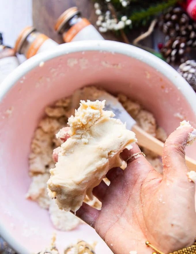 A hand holding the sugar cookie dough when finished to show the texture of the soft dough, not sticky and not dry, but rather soft