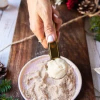 A hand scooping 1 inch size sugar cookie dough