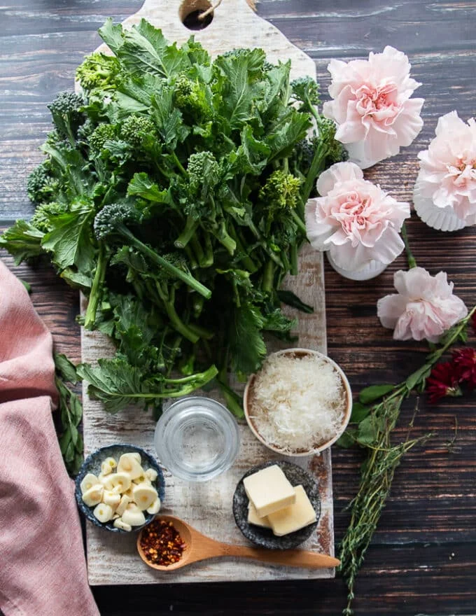 Ingredients needed to cook broccoli rabe including olive oil or butter, garlic, the broccoli rabe and some parmesan cheese