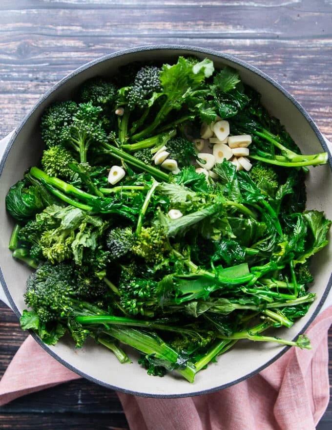 Broccoli Rabe and garlic slices in a deep oval skillet with butter or olive oil, sautéed