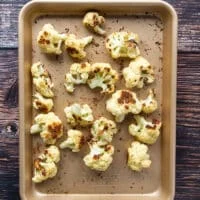 the cauliflower florets in a baking sheet, roasted and golden, ready to use