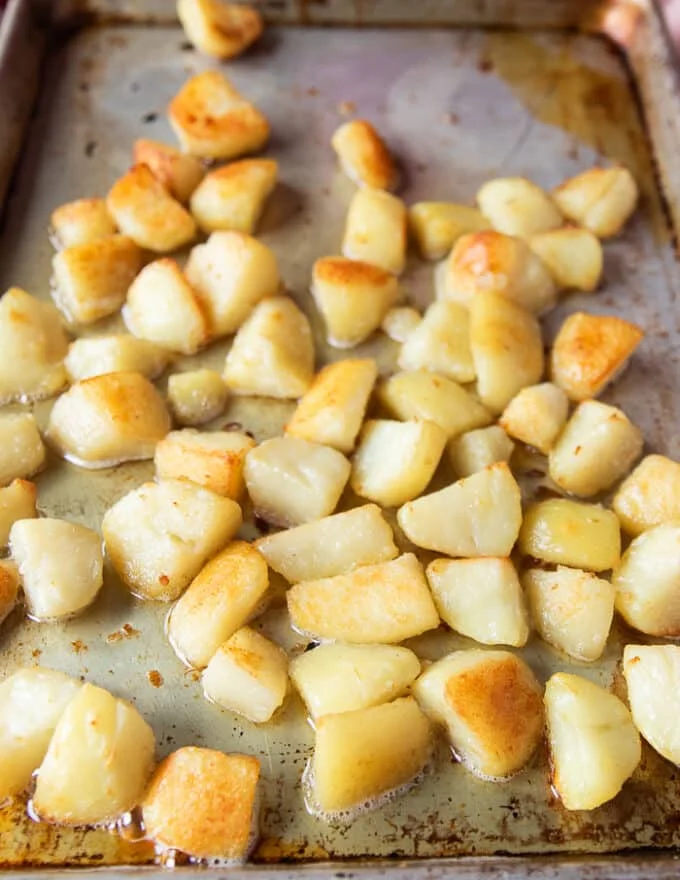 halfway roasted crispy potatoes being tossed around for ven browning
