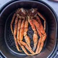 Air fried crab legs ready to eat in an air fryer basket