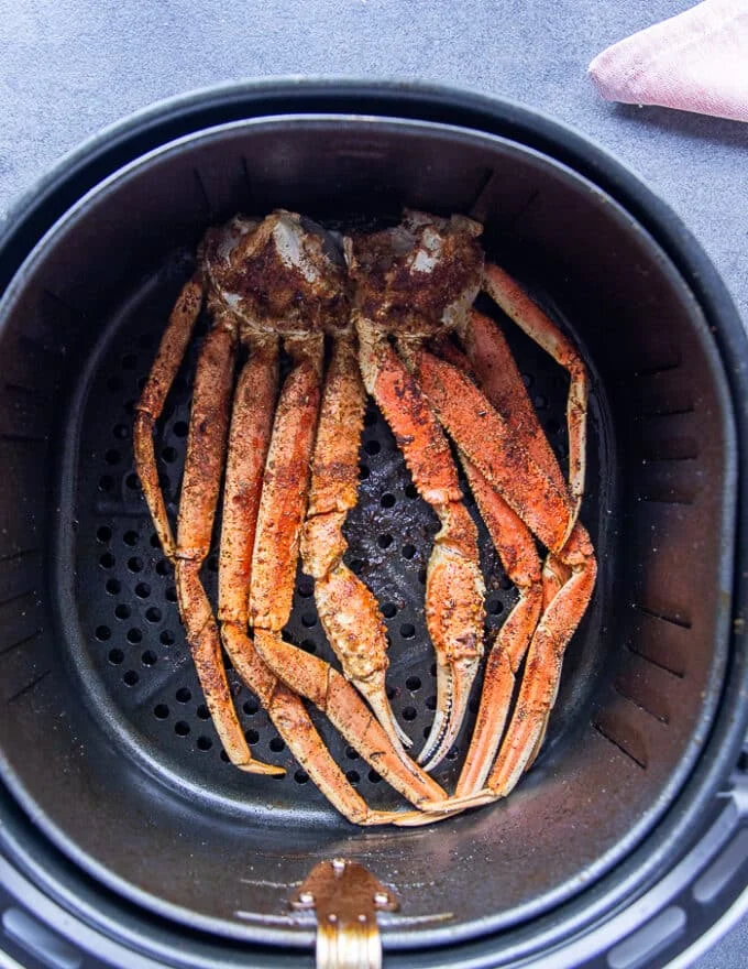 Air fried crab legs ready to eat in an air fryer basket