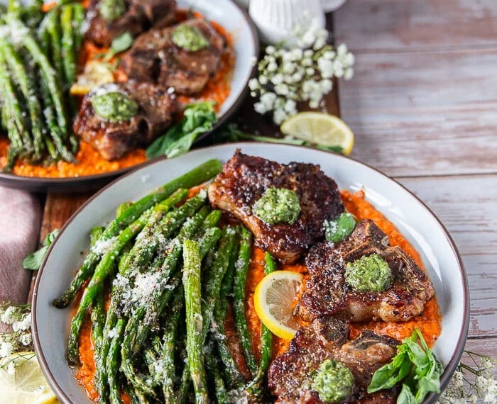 side view of a plated lamb chops dinner showing the thickness of the cooked lamb chops