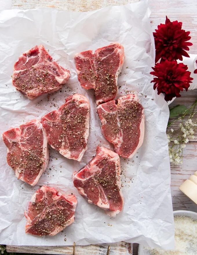 lamb chops on a paper seasoned liberally with coarse salt and pepper on both sides