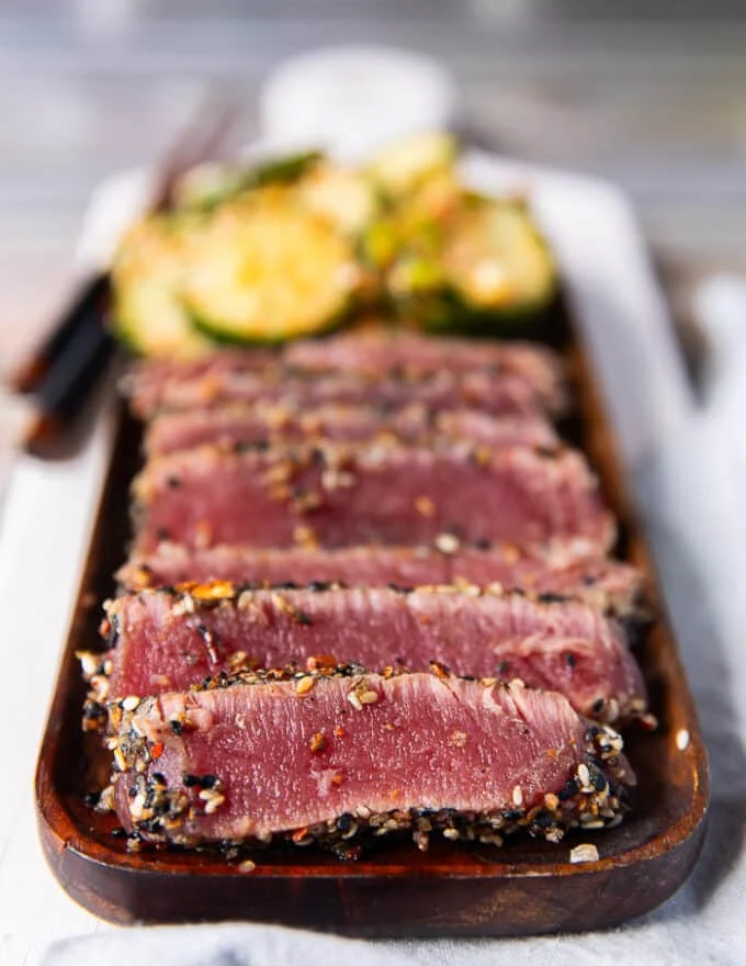 close up of a plate of seared ahi tuna stacked in slices