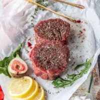 two pieces of fillet mignon seasoned on both sides with generous amounts of salt and pepper