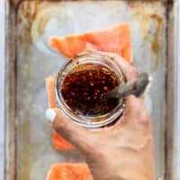 A hand holding the homemade sweet chili sauce