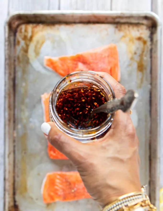 A hand holding the homemade sweet chili sauce