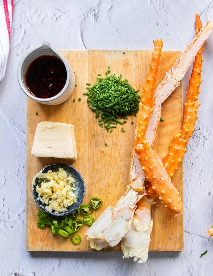 Ingredients to make creamy chili crab pasta including crabs, butter,, chili oil, garlic, chives and some cream
