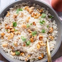 close up of a pot of coconut rice with cashews and cilantro, perfectly fluffy and tasty coconut rice recipe