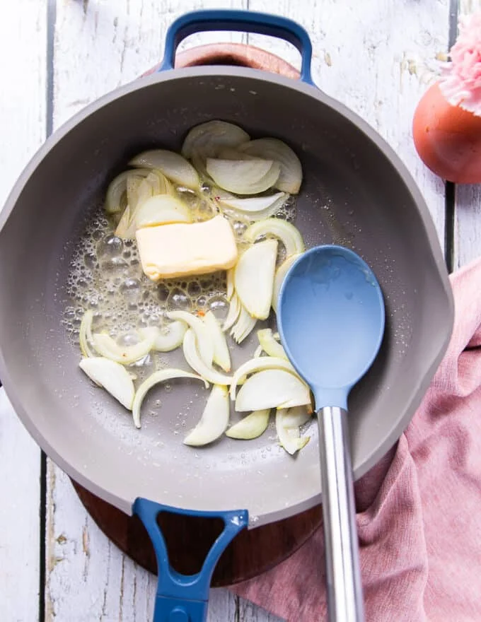 Onion and butter sautéing in the pan to cook the rice