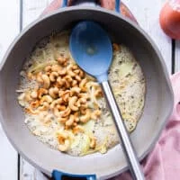 Cashews are added to the rice pan with onion and butter when the onions have softened