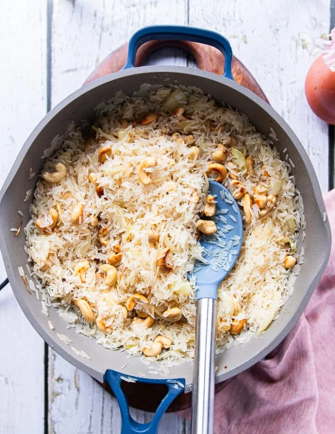 The rinsed rice added to the pan to be sautéed with the remaining ingredients very well before proceeding