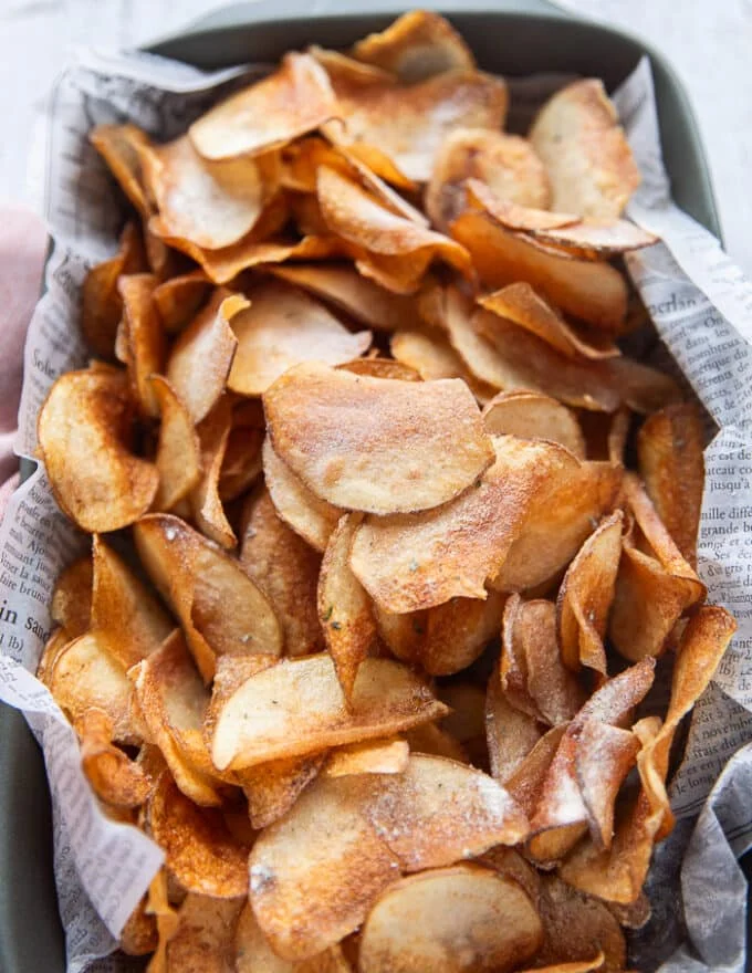A large plate of homemade potato chips and a sprinkle of ranch seasoning on top