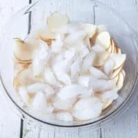 Thinly sliced potatoes in an ice bowl soaking for potato chips