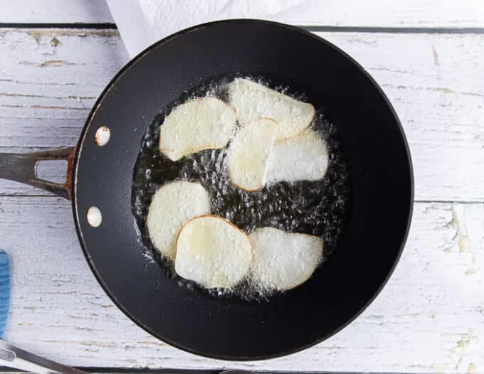 a few potato slices frying in very hot oil