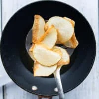 A slotted spoon slipping the chips in the hot oil