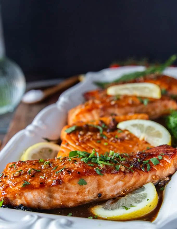 A plate of maple glazed salmon with the maple glaze golden and toasty over the salmon