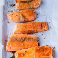 fully maple glazed salmon fillets on a baking sheet ready to go in to the oven