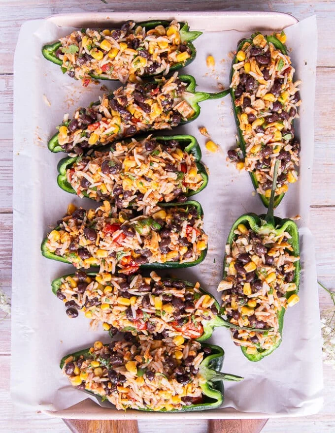 The poblano pepper halves on the baking sheet filled with the stuffing