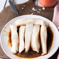 The halibut pieces added to the marinade plate and tossed