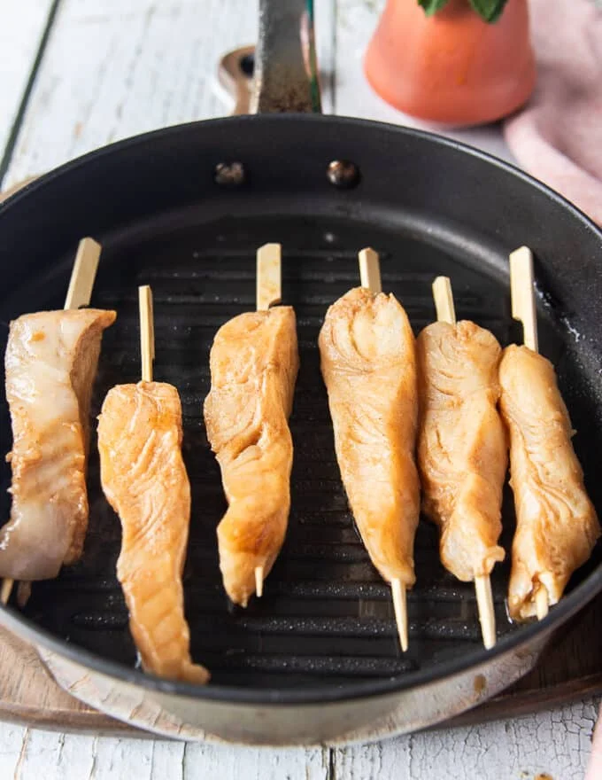 Halibut skewers on a hot indoor grill, all in one layer