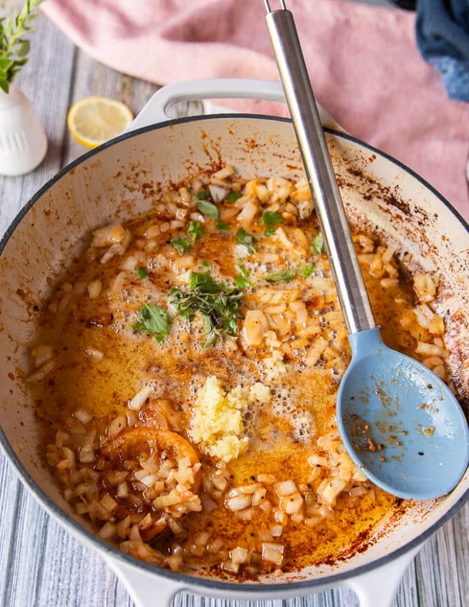The shallots and garlic are sautéing in the same skillet as the butter poached lobster
