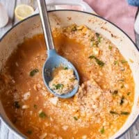 the first batch of lobster stock is added over the rice in the skillet to make risotto