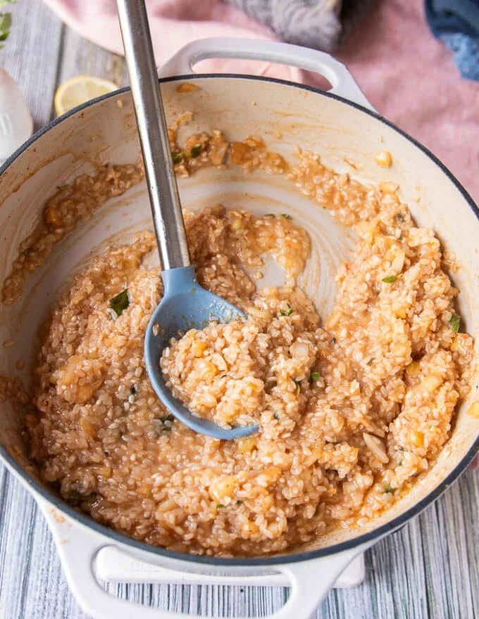 The risotto has absorbed the initial amount of stock and looks creamy and ready for more