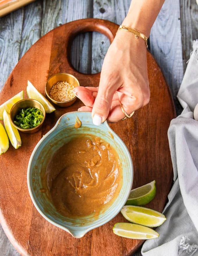 A hand holding a bowl of the miso marinade mixed well and ready to use
