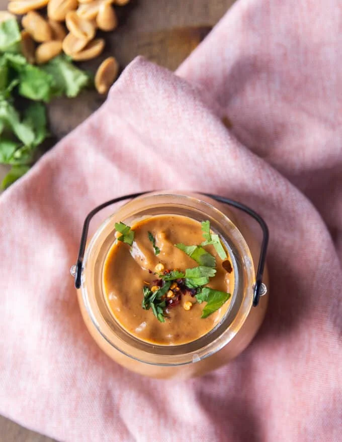 top view of a jar of satay sauce ready and garnished