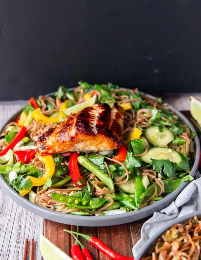 cold soba noodles salad on a plate, with veggies , herbs and dressing