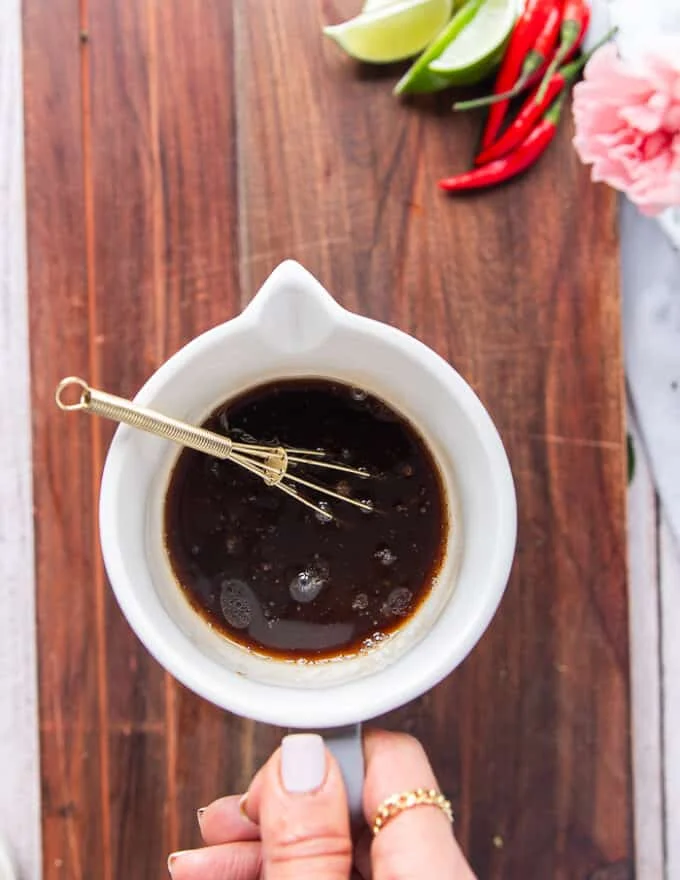 A bowl with soy sauce, sesame oil, rice vinegar, sugar, seasoning mixed together to make the sauce for soba noodles recipe