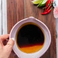A bowl of soy sauce, rice vinegar and honey used to make the dressing for the saba noodle salad
