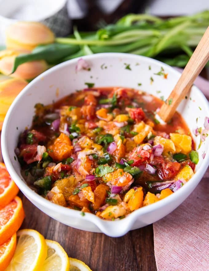 The citrus salsa mixed and a spoon is still in the bowl showing close up the textures