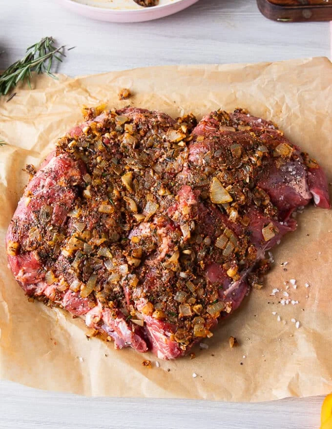 The onion mixture is pressed well into the lamb