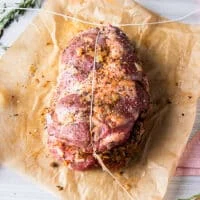 The first step to tying up the boneless leg of lamb is to tie the meat vertically and make a tight knot