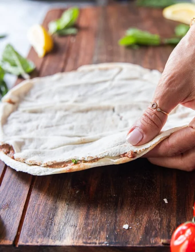 The top layer of the thin pita bread is now placed over the meat filling and pressed down
