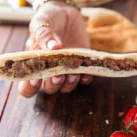 the meat mixture is pressed firmly into the pita bread